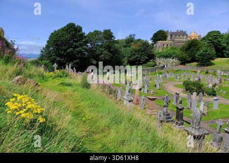 Stirling: Castello di Stirling, cimitero della città vecchia, lapidi, fiori, sentiero erboso, colline e cielo blu dal punto di vista di Stirling, Scozia, Regno Unito Foto Stock