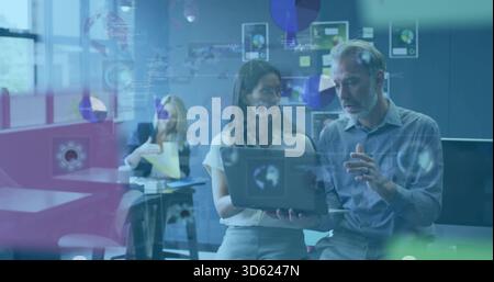 Collaborare con due colleghi in abiti da lavoro per visualizzare un laptop in ufficio con un vetro che mostra i dati Foto Stock