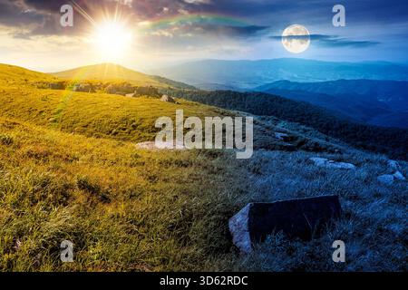verdi prati alpini in montagna al solstizio d'estate. concetto di cambiamento di orario diurno e notturno. pietre su colline erbose con sole e luna al crepuscolo. dualità Foto Stock