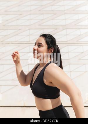 Ritratto di una donna, felice, in un momento di danza e movimenti per rilassarsi e disconnettersi Foto Stock