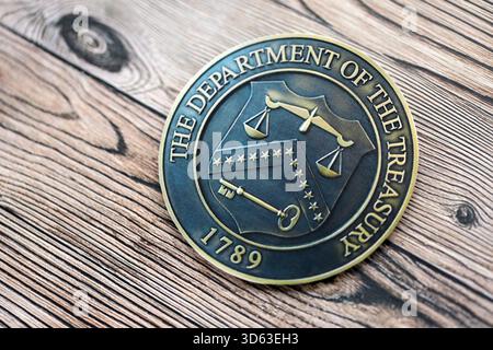 KYIV, UKRAINE - OCTOBER 7, 2025 US Department Of The Treasury emblem on wooden table surface close up Foto Stock