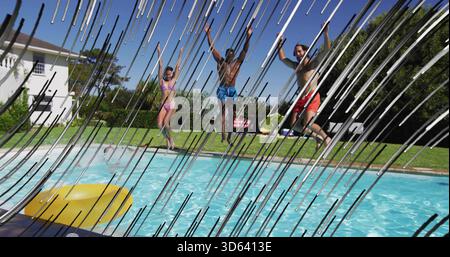 Salta tre amici con bikini rosa e pantaloncini nella piscina del cortile con anello gonfiabile giallo Foto Stock
