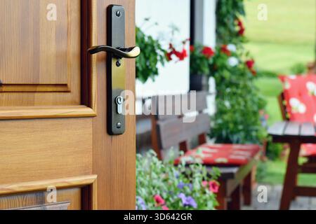 Metà porta aperta sulla splendida terrazza estiva e sul giardino fiorito Foto Stock