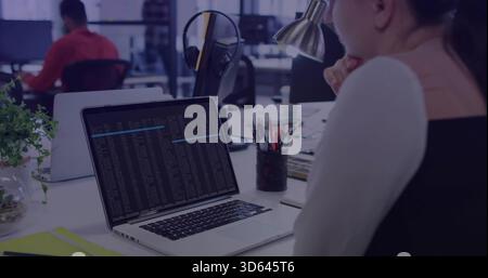 Donna pendente che studia il terminale portatile in un ufficio aperto, indossa la parte superiore nera senza maniche, spazio fotocopie Foto Stock