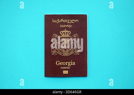 Libretto dei passaporti georgiani su sfondo di carta blu chiaro primo piano. Documento di viaggio su superficie blu Foto Stock