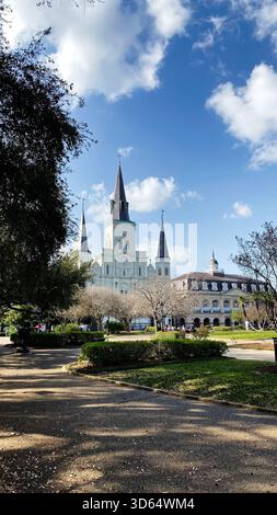 New Orleans, Louisiana, Stati Uniti - 15 marzo 2025: Cattedrale illuminata dal sole con alte guglie accanto a un parco di New Orleans, Louisiana, Stati Uniti. Foto Stock