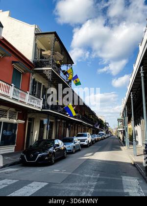 New Orleans, Louisiana, Stati Uniti - 15 marzo 2025: Una soleggiata scena Street di New Orleans con balconi ornati, colorati Saint Vincent e Grenadine Foto Stock