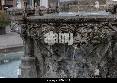 Primo piano di beccucci di gargoyle in pietra ornata su una fontana storica a Göttingen, Germania Foto Stock