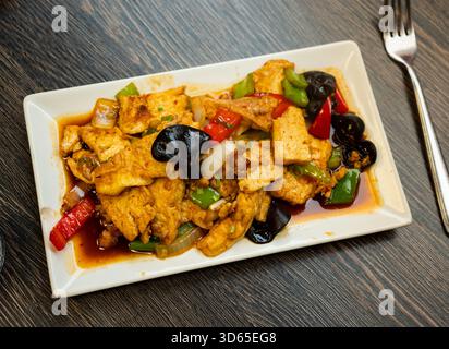 Tofu stufato con verdure su un piatto Foto Stock