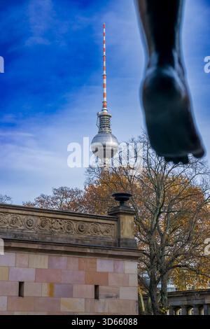 Vista della torre della televisione di Berlino (Fernsehturm) vista dall'Isola dei Musei, incorniciata dai piedi della scultura "Amazone zu Pferde" di Louis Tuaillon, Germania. Foto Stock