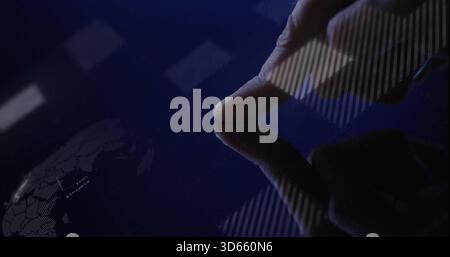 Premere la punta destra indossando la manica scura sullo schermo lucido in uno spazio di lavoro poco illuminato, con la mappa del mondo Foto Stock