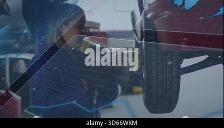 Riparazione meccanica donna in tute blu scuro serraggio ruota con chiave pneumatica, rivestimento garage Foto Stock