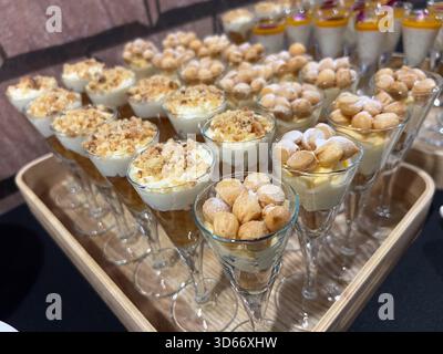 Mini dessert assortiti in tazze di vetro durante l'evento con catering Foto Stock
