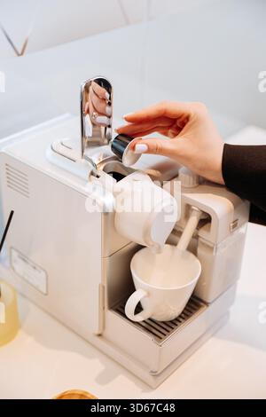 Inserire manualmente la capsula di caffè nella macchina espresso con la tazza, chiudere Foto Stock