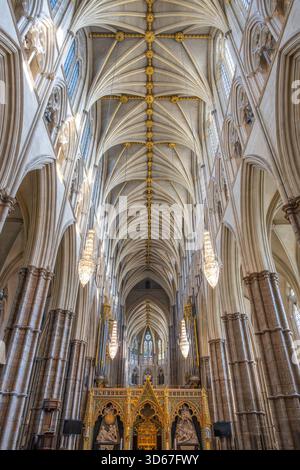 L'abbazia di Westminster presenta un complesso design gotico con archi alti e dettagli artigianali. La luce del sole filtra attraverso le vetrate colorate, illuminando questo storico luogo di culto di Londra. Foto Stock