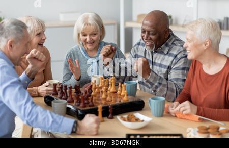 Gruppo emozionale multietnico di persone anziane che giocano a scacchi Foto Stock