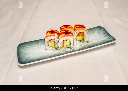 Tonno Uramaki piccante con tonno piccante e avocado all'interno, semi misti di sesamo all'esterno Foto Stock