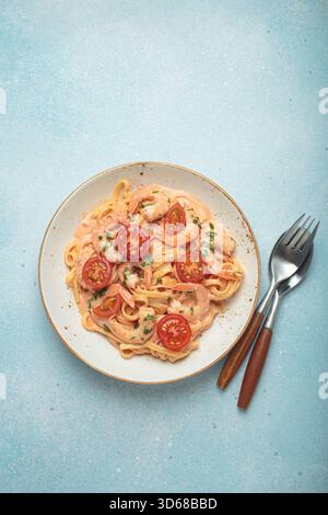 Linguine di pesce in salsa cremosa con gamberi e pomodori Foto Stock