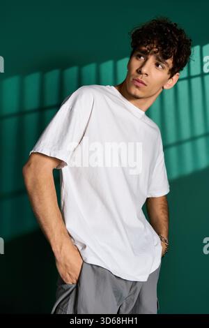 Modello dai capelli ricci che indossa abiti casual in un elegante studio. Foto Stock