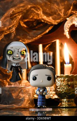 Funko Pop action figure di Lorraine Warren e la suora del film horror Conjuring. Antico tempio buio, la candela accesa brucia nel semi-buio. Foto Stock