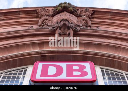 DB-Logo am Haupteingang des Wiesbadener Hauptbahnhofs 17.11.25, Wiesbaden: Symbolfoto, Illustrationsbild, Symbolbild, Illustrationsfoto, Alltagsszene Ein DB-Logo am Eingang des Wiesbadener Hauptbahnhofs, aufgenommen aus der Froschperspektive. über dem Schild ist ein historisches Sandsteinornament der Fassade zu sehen. DAS Bild zeigt die Architektur des Hauptbahnhofs Wiesbaden und das typische Branding der Deutschen Bahn. Wiesbaden Hessen Deutschland *** Logo DB all'ingresso principale della stazione centrale di Wiesbaden 17 11 25, foto simbolo di Wiesbaden, immagine illustrazione, immagine simbolo, illustrazione pho Foto Stock