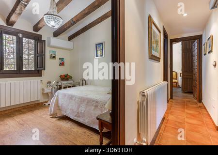 Incantevole camera da letto collegata al corridoio, con arredamento rustico, accenti in legno e luce naturale Foto Stock