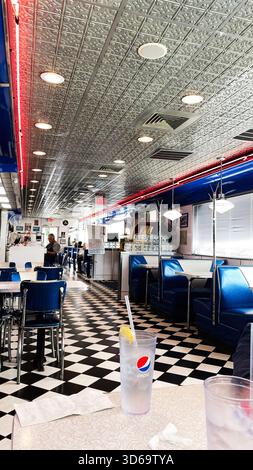 Portsmouth, New Hampshire, Stati Uniti d'America - 20 maggio 2024: Ristorante USA con cabine blu, accenti cromati e una fredda tazza Pepsi. Foto Stock