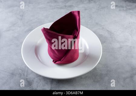 Vista di una piega del tovagliolo su un piatto. Foto Stock