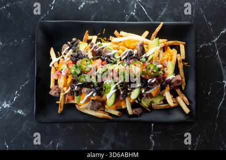 Vista dall'alto di un piatto di patatine fritte di carne asada. Foto Stock