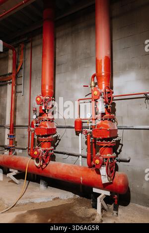 Valvole sprinkler antincendio e tubi rossi in impianti industriali, attrezzature di sicurezza, vista verticale Foto Stock