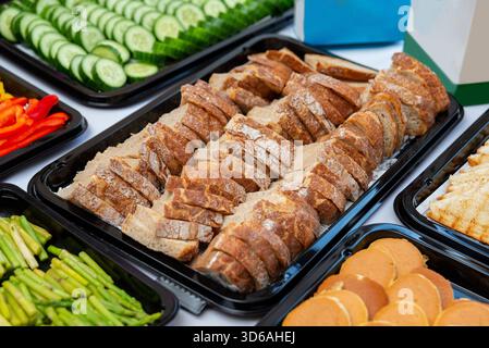 Un vivace assortimento di cibi esposti per gli eventi, con pane affettato, verdure fresche e vari antipasti. perfetto per eventi sociali e privati Foto Stock