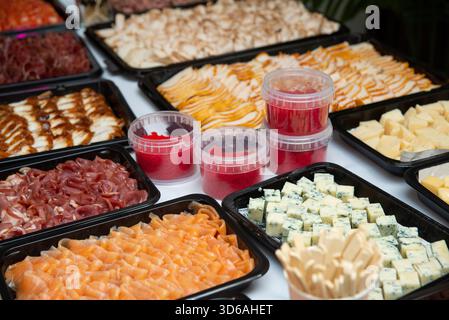 Una varietà di cibi gourmet ordinati su un tavolo, con salmone affumicato, formaggi assortiti, affettati e deliziosi spalmabili. perfetto per cate Foto Stock
