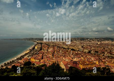 Ampia vista panoramica su Nizza, Francia, con tetti, costa e la curva della Baia degli Angeli sotto nuvole spettacolari. Foto Stock