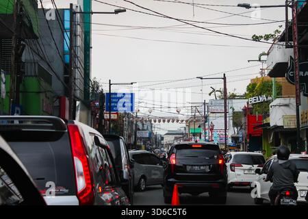 Bogor, Indonesia - 20 ottobre 2025: Traffico intenso su Surya Kencana Street, Bogor, Indonesia. Auto e motociclette affollano la stretta strada della città. Foto Stock
