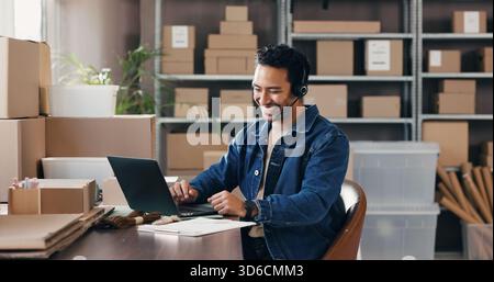 Auricolare, distribuzione e uomo in ufficio con computer portatile per l'assistenza clienti, informazioni sugli ordini e spedizione. Logistica, computer e lavoratore felice con microfono per Foto Stock