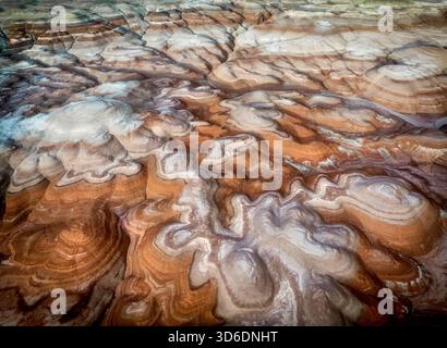La vista aerea delle formazioni rocciose sedimentarie a strati crea un ipnotico arazzo di tonalità terrose e motivi intricati, Hanksville, Utah, Stati Uniti Foto Stock