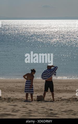 I nuotatori cambieranno nel tardo pomeriggio appena prima del tramonto a Tangaloma Beach, Tangalooma, Moreton Island, Queensland, Australia Foto Stock