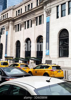 New York, USA - 19 novembre 2023: Vivace scena newyorkese con Moynihan Train Hall con taxi, architettura ed energia urbana. Foto Stock