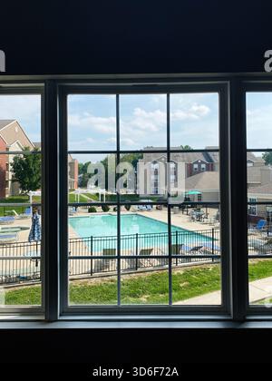 Giornata luminosa in un complesso di appartamenti periferici con piscina, vista attraverso una grande finestra nell'Illinois meridionale. Foto Stock