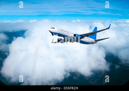 Aereo che vola in alto nel cielo, primo piano di un aereo bianco nel volo sopra le nuvole sulla superficie terrestre, sfondo del viaggio aereo Foto Stock