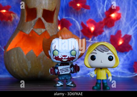 Funko Pop action figure di clown Pennywise e Georgie del film horror IT. Arredamento di Halloween, Jack o lanterna, ragnatela, foglie, luci. Foto Stock