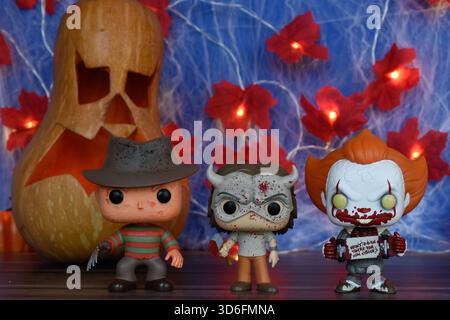 Funko Pop action figure di personaggi horror Freddy Krueger, The Grabber e Pennywise clown. Halloween, Jack o lanterna, ragnatela, foglie, luci. Foto Stock