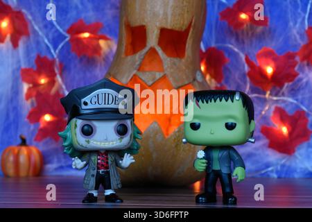 Funko Pop action figure dei personaggi horror Beetlejuice e il mostro di Frankenstein. Arredamento di Halloween, Jack o lanterna, ragnatela, foglie, luci. Foto Stock