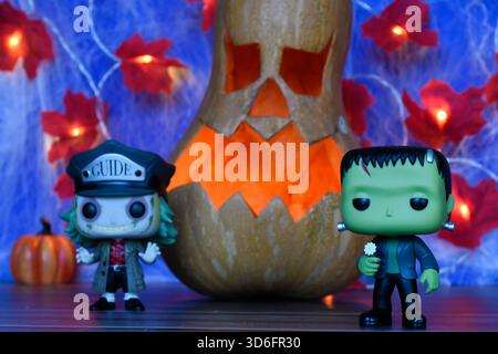 Funko Pop action figure dei personaggi horror Beetlejuice e il mostro di Frankenstein. Arredamento di Halloween, Jack o lanterna, ragnatela, foglie, luci. Foto Stock