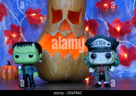Funko Pop action figure dei personaggi horror Beetlejuice e il mostro di Frankenstein. Arredamento di Halloween, Jack o lanterna, ragnatela, foglie, luci. Foto Stock