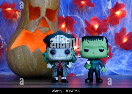 Funko Pop action figure dei personaggi horror Beetlejuice e il mostro di Frankenstein. Arredamento di Halloween, Jack o lanterna, ragnatela, foglie, luci. Foto Stock