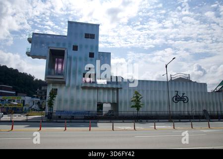 Un moderno edificio lungo il percorso ciclabile ospita un centro informazioni, con simboli e insegne sulla sua facciata ondulata vicino al centro di C. Foto Stock