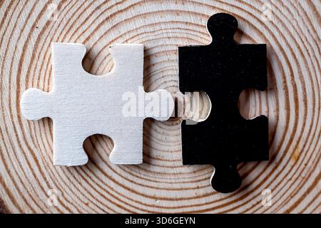 Contrasto macro: Pezzi di seghetto alternativo in bianco e nero allineati su una superficie legnosa con crescita Foto Stock