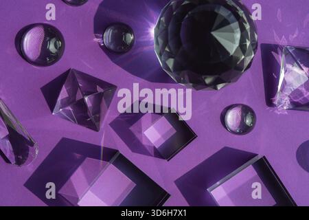 Luce rifrangente a prisma di cristallo, cristalli magici e piramide, sfera e cubo su sfondo viola. Pratica di cristallo di guarigione spirituale. Feng Shui, bravo Foto Stock
