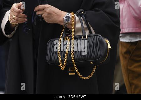 Parigi, Francia - 11 marzo 2025: Borsa Miu Miu Miu trapuntata rettangolare nera con chiusura a catena oro. Outfit Street style Foto Stock
